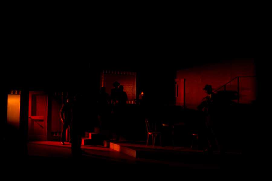 Gangsters in near darkness with touches of red light